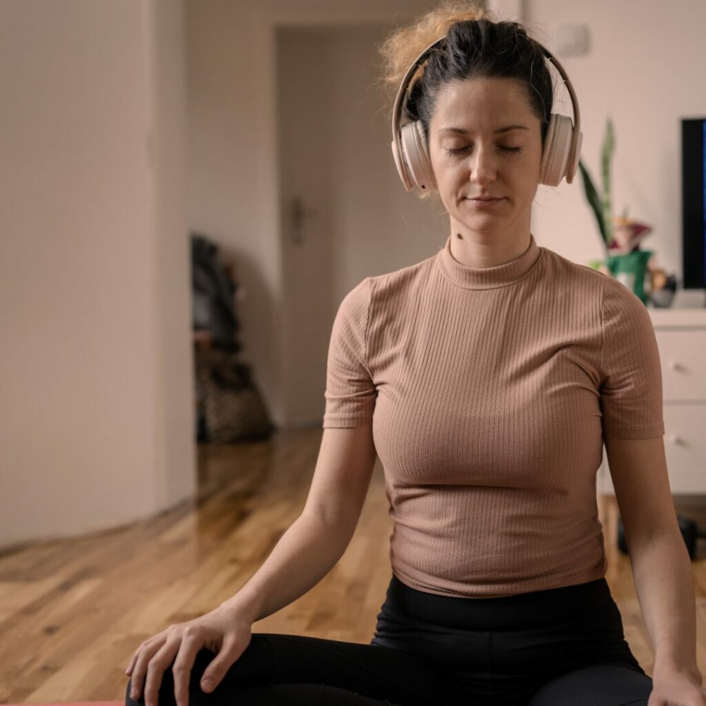 Una ragazza in casa che fa meditazione.