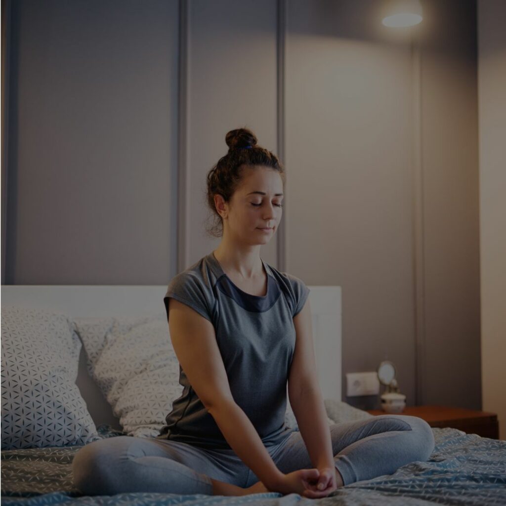 Perfect night routine: a woman meditating in bed