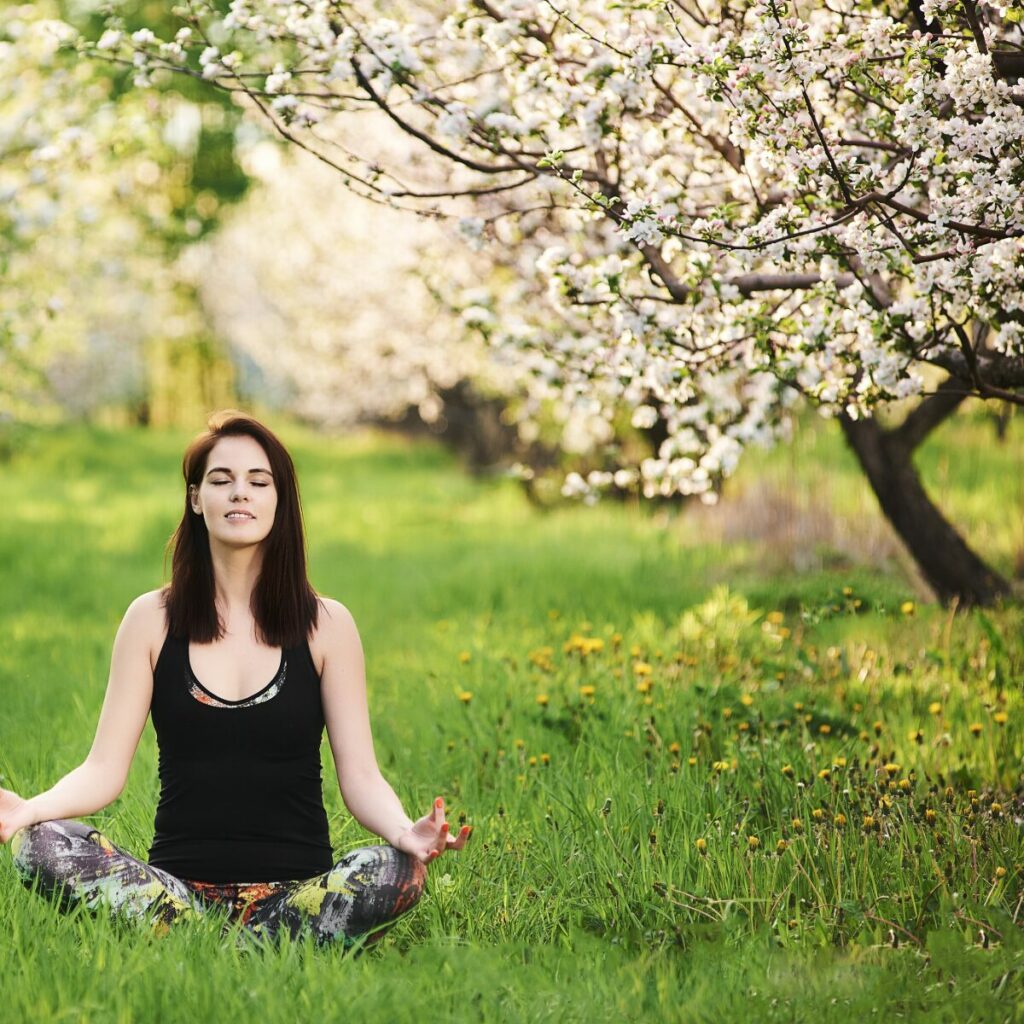 Morning routine perfetta: ragazza che medita su un prato